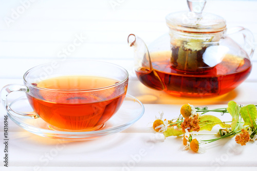 Tea teapot cup herbal wood background 