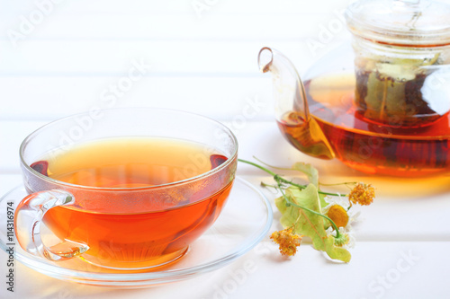 Tea teapot cup herbal wood background 