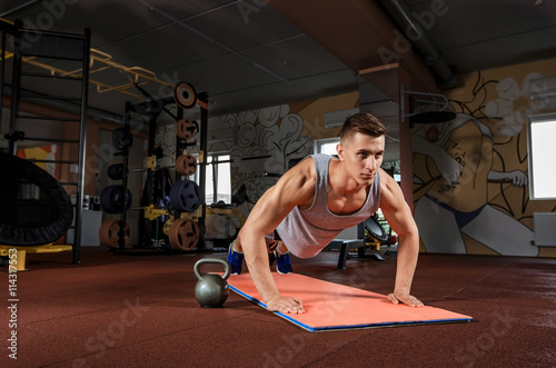 Young man doing exercises in the gym