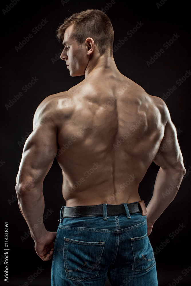 Fototapeta premium Muscular bodybuilder guy doing posing over black background