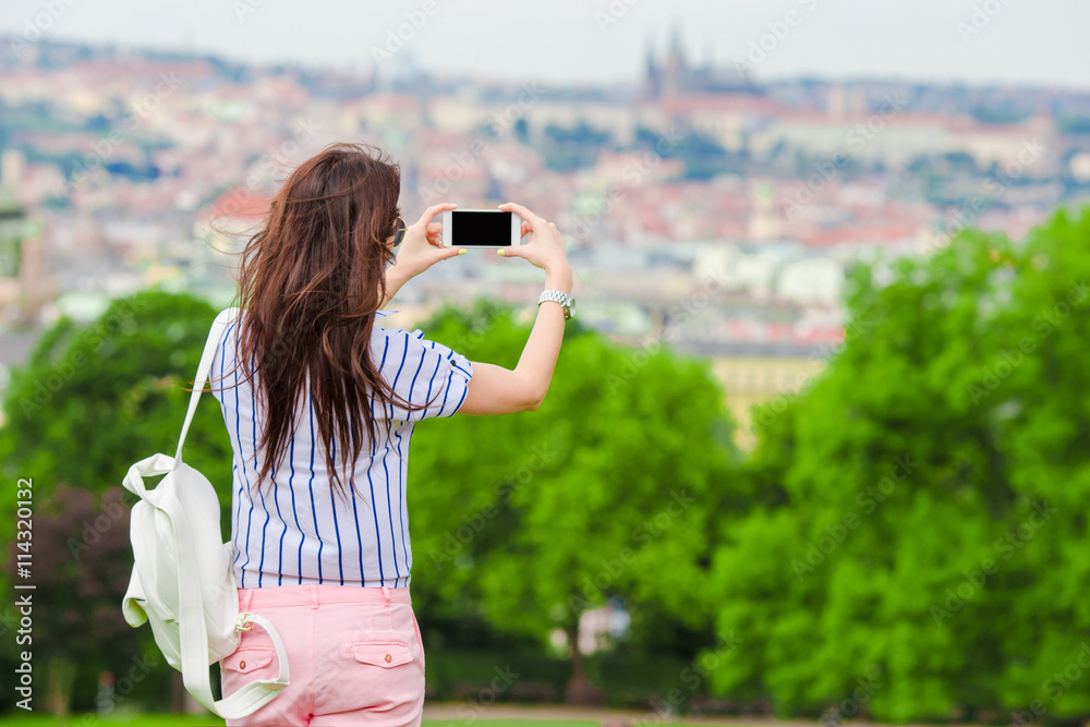 Φωτογραφία Young caucasian woman making photo of european old city by mobile phone from the
