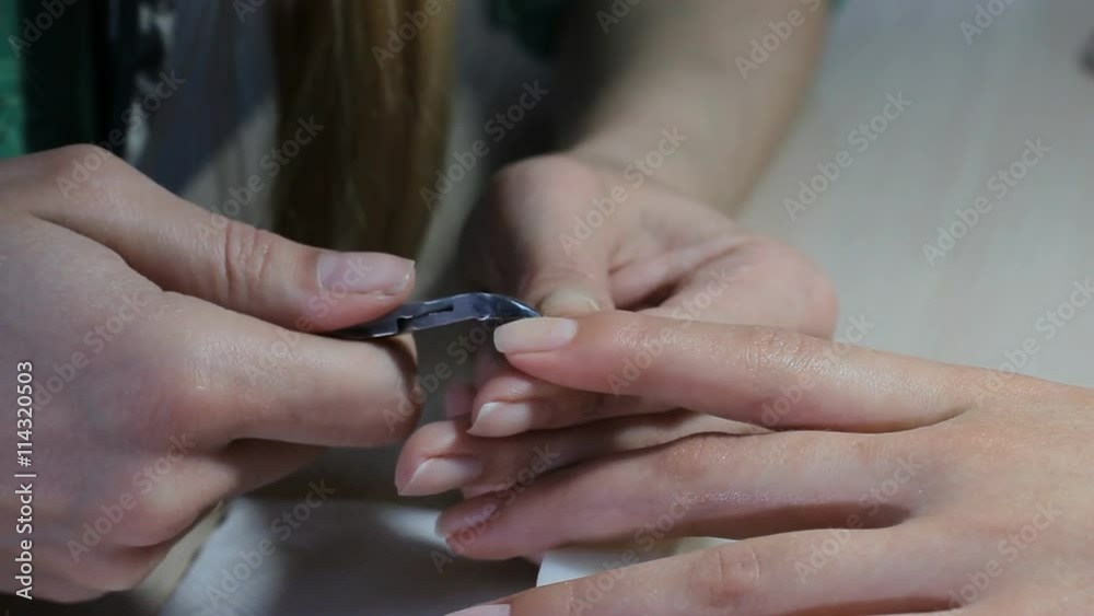 Nail technician giving customer a manicure at nail salon. Young woman receiving a french manicure. Young caucasian woman receiving a french manicure. Nail technician giving customer a manicure at nail salon. Young woman receiving a french manicure. Young caucasian woman receiving a french manicure.