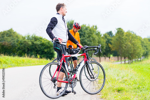 Zwei Sport Radfahrer, abgestiegen, machen eine Pause