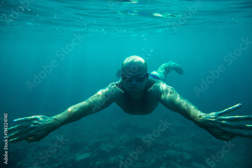 man swim underwater sea