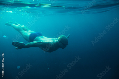 man swim underwater sea