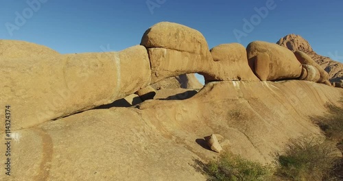 4K aerial shot flying through the granite arch of the Spitzkoppe mountains photo