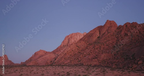 4K panning shot of the moon setting over granite peaks of the Spitzkoppe mountains photo
