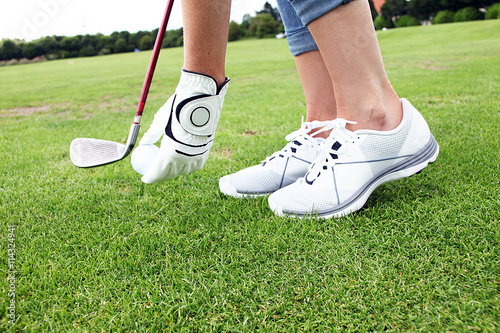 Golferin legt Ihren Golfball zum Abschlag auf