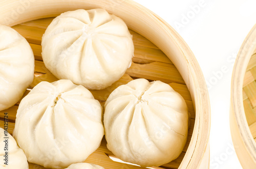 Chinese steamed buns in bamboo steamer basket isolated on white