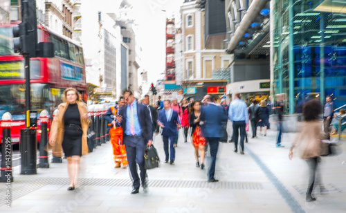 Business people walk through the City of London street. Blurred image. City of London business life concept 