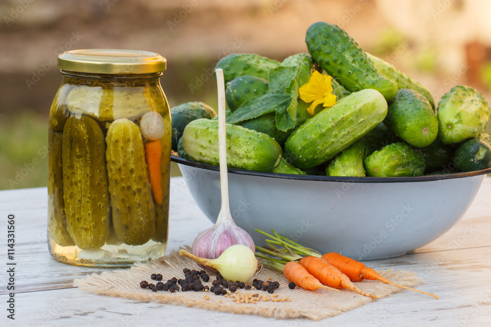 Cucumbers in metal bowl, vegetables and spices for pickling and jar pickled cucumbers Cucumbers in metal bowl, vegetables and spices for pickling and jar pickled cucumbers