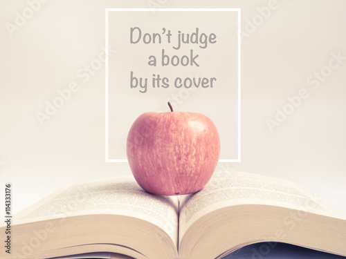 Red apple on an open book with wording