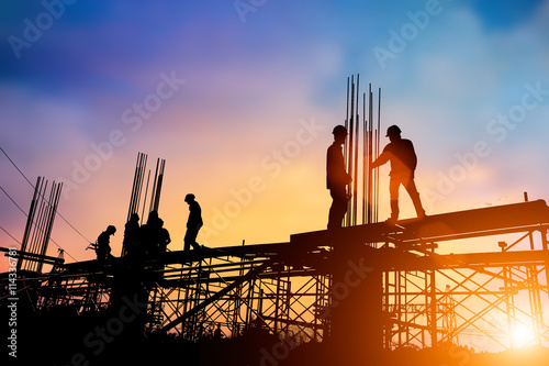 Silhouette engineer standing orders for construction crews to wo photo