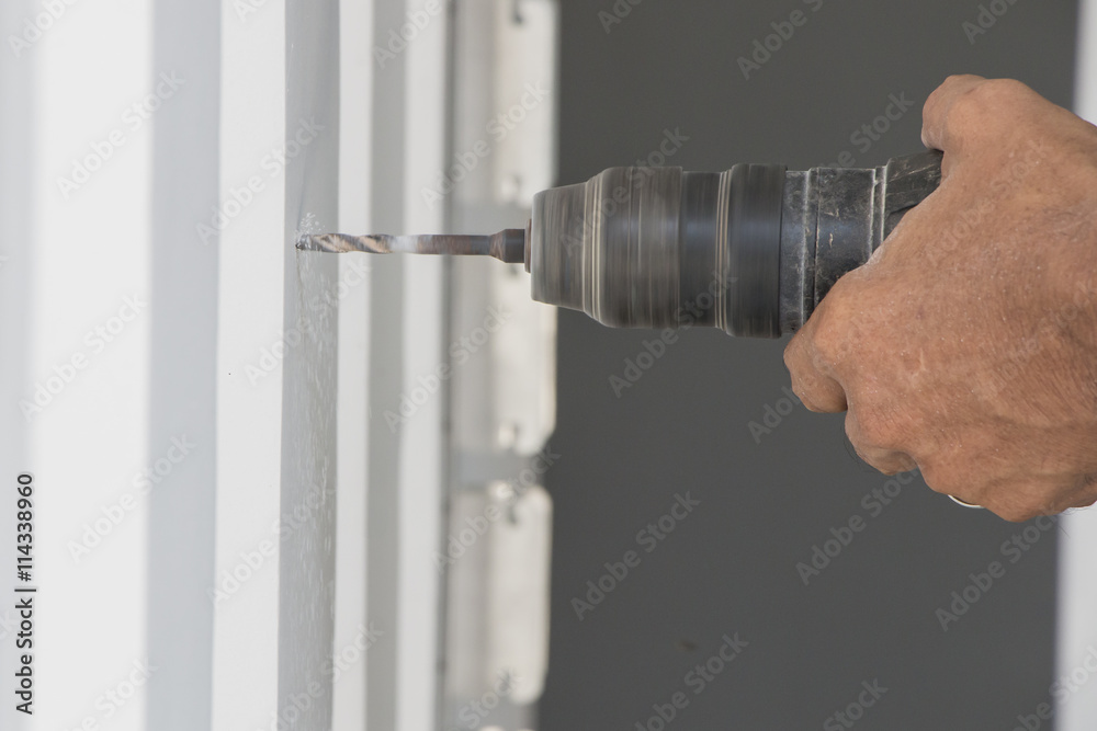 Builder or worker drilling with a machine or drill Builder or worker drilling with a machine or drill