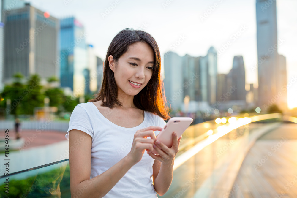 Asian woman use of mobile phone at sunset