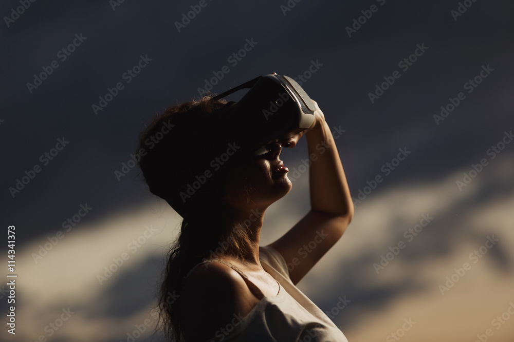 Woman wearing virtual reality goggles outside in spring nature Woman wearing virtual reality goggles outside in spring nature