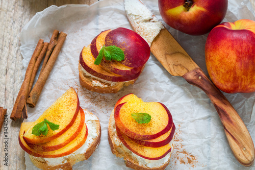 Healthy Breakfast. Bruschetta with peach,nectarine, cottage cheese, cinnamon and mint. Selective focus 