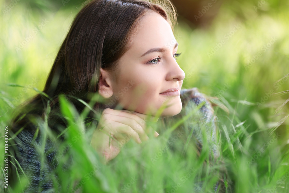 Young beautiful girl laying on green grass Young beautiful girl laying on green grass