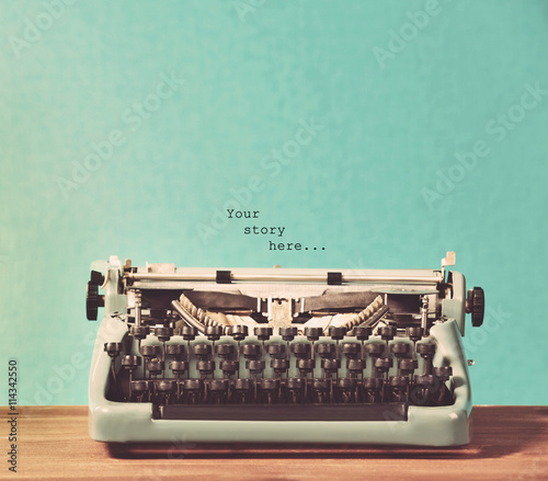 Old retro typewriter on table on blue background photo