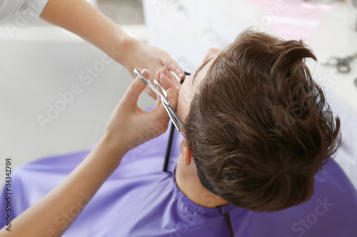 Professional hairdresser making stylish haircut