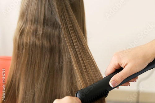 Professional hairdresser straightening hair