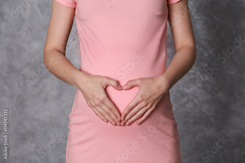 Wallpaper Mural Pregnant woman on gray wall background, close up Torontodigital.ca