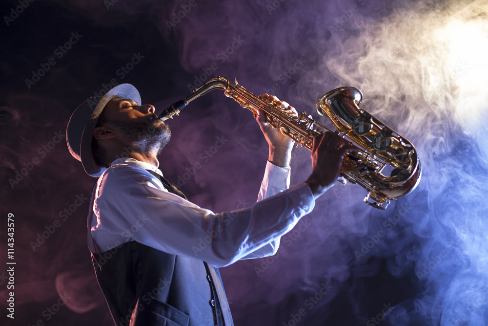 Naklejka premium Saxofonista sobre escenario con humo