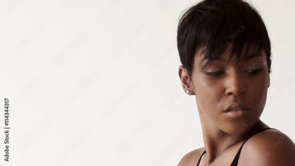 Attractive sexy black woman poses on camera in black body, isolated on white with moving focus Attractive sexy black woman poses on camera in black body, isolated on white with moving focus