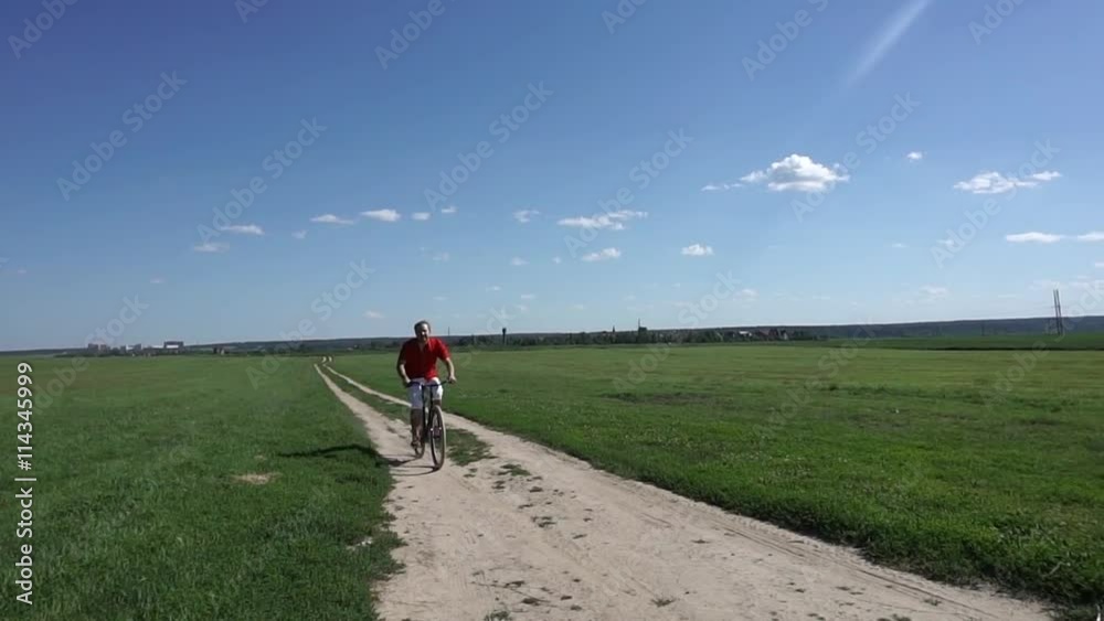 Summer field classical bicycling, slow motion steadicam shot Summer field classical bicycling, slow motion steadicam shot