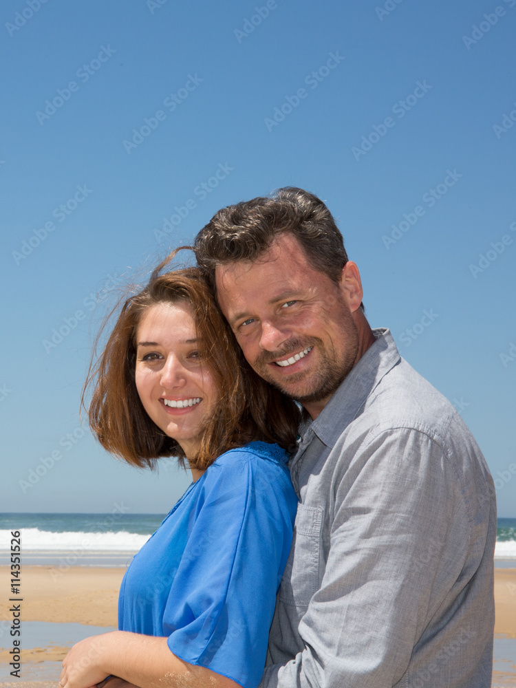 Lovely couple looking at camera together at summer beach Lovely couple looking at camera together at summer beach
