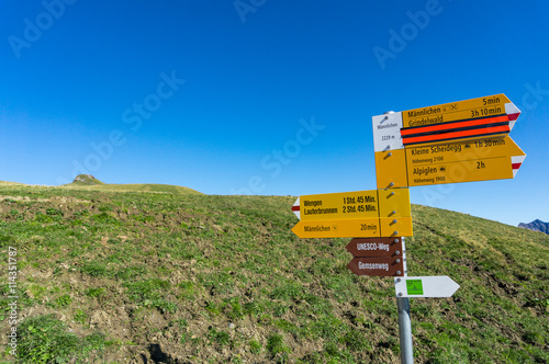 Sign post of swiss alps indicating the hiking trail at Mannliche