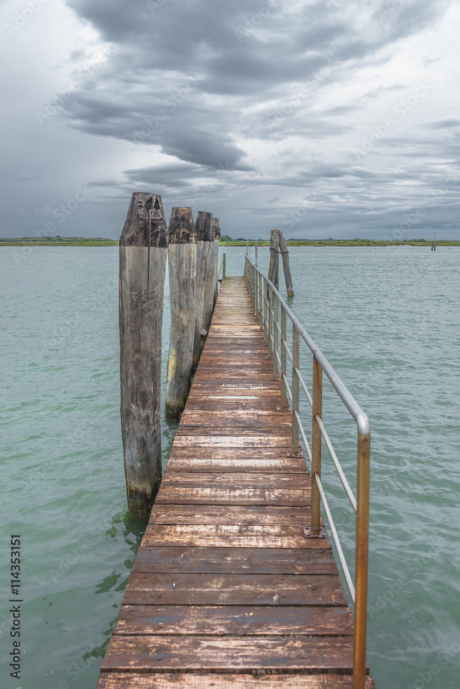 Fototapeta premium Wooden old pier at Burano, an island nearby Venice, Italy