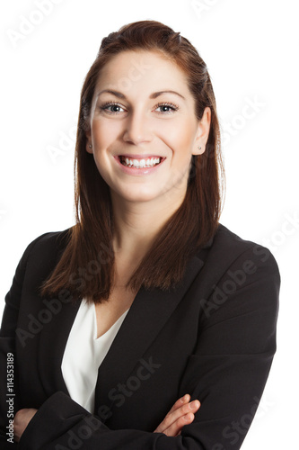 An attractive brunette businesswoman wearing a black suit and white shirt, standing with her arms crossed against white background.