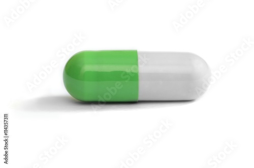 Green and white colored pill on white background