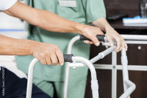 Patient's Hands Holding Walker By Nurse In Rehab Center