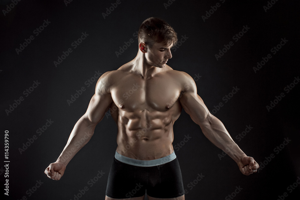 Muscular bodybuilder guy doing posing over black background Muscular bodybuilder guy doing posing over black background