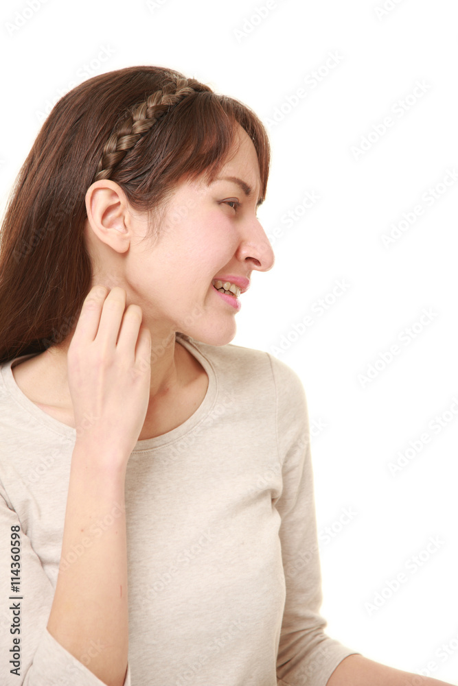 激しい痒みに首を搔きむしるアラサーの女性