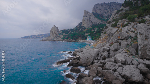 Catholic and Protestant church on the beach, at the foot of the mountain. photo