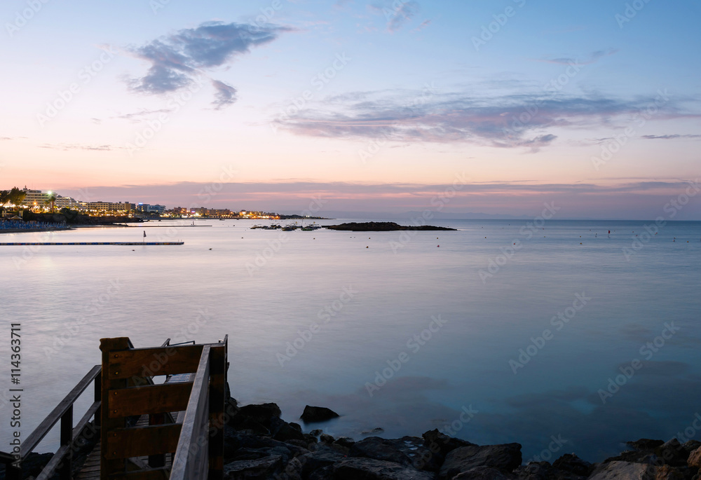 Obraz premium Photo of sea in protaras, cyprus island, with rocks and hotels at sunset.