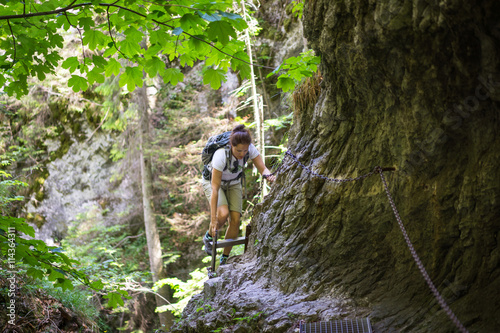 Young woman on a difficult trail in Slovak Paradise National Park. Horizontal view of challenging trail in a Slovak Paradise NP.