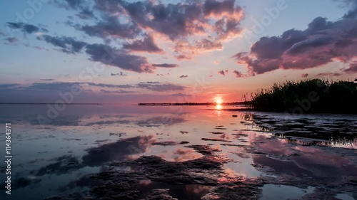 Timelapse of a beautiful sunset, reflected in the water. 4k foota photo