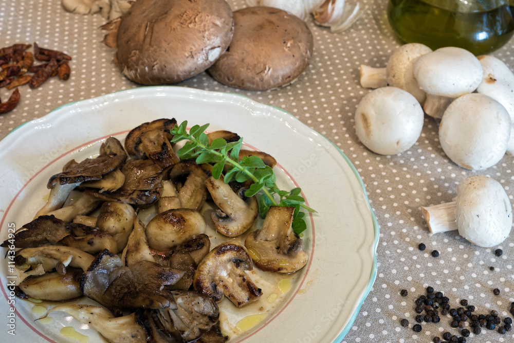 White plate of cooked mushrooms in kitchen