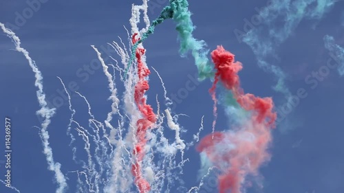 Colorful daytime fireworks on blue sky background
