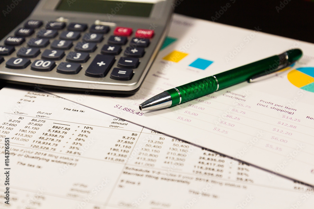 Pen and calculator on paper table with diagram Pen and calculator on paper table with diagram