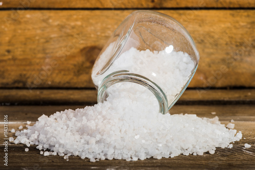 White salt on a wooden background.