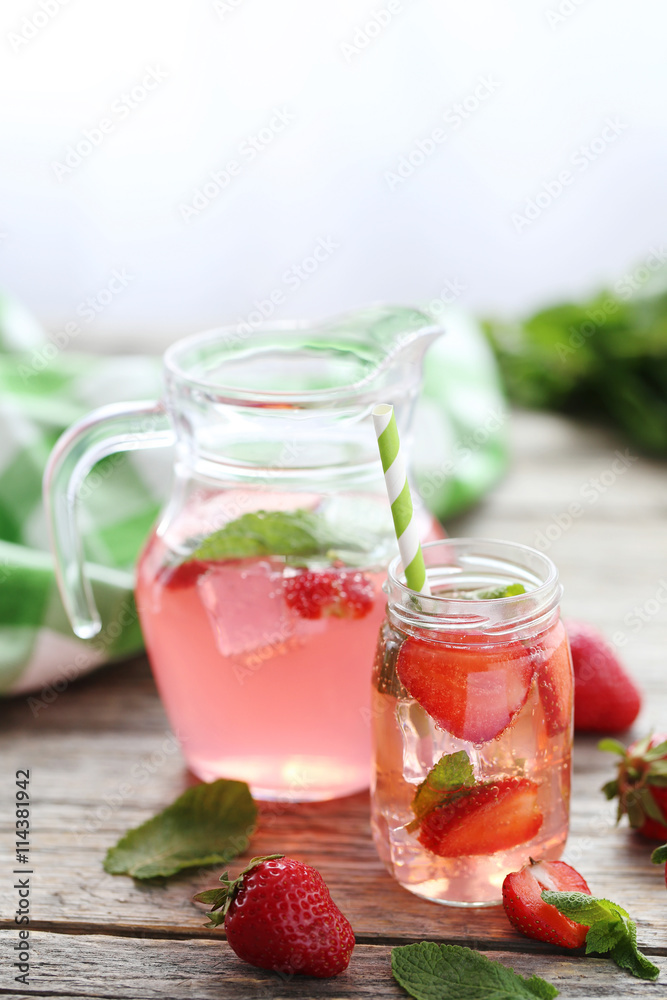 Fresh strawberry drink in bottle on wooden table Fresh strawberry drink in bottle on wooden table