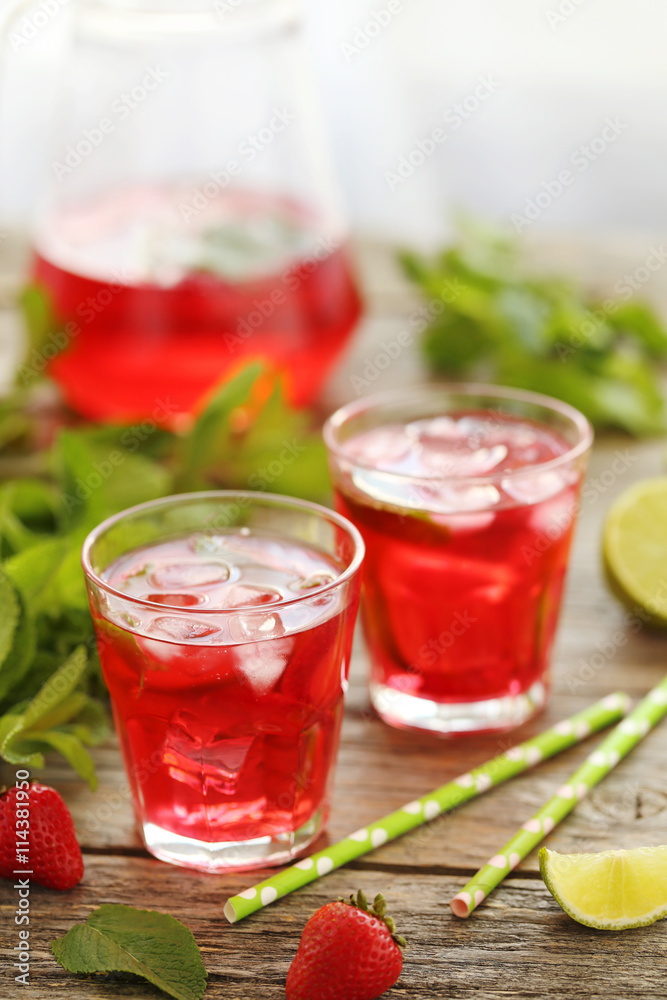Fresh strawberry drink in glass with lime on wooden table Fresh strawberry drink in glass with lime on wooden table