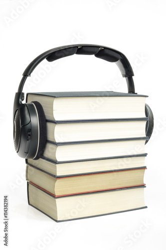 Group of books and headphones related to audio books on isolated background photo