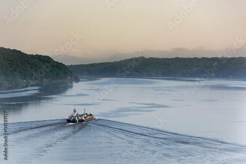 Dawn on the Hudson River: Sunrise beginning on the Hudson River near Poughkeepsie as a cargo ship makes its way northward towards Albany, NY