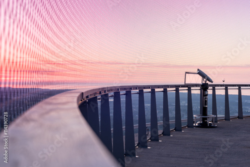 Panoramic view of a sunset sky from sightseeing sky-high platform with binoculars covered with protective fence